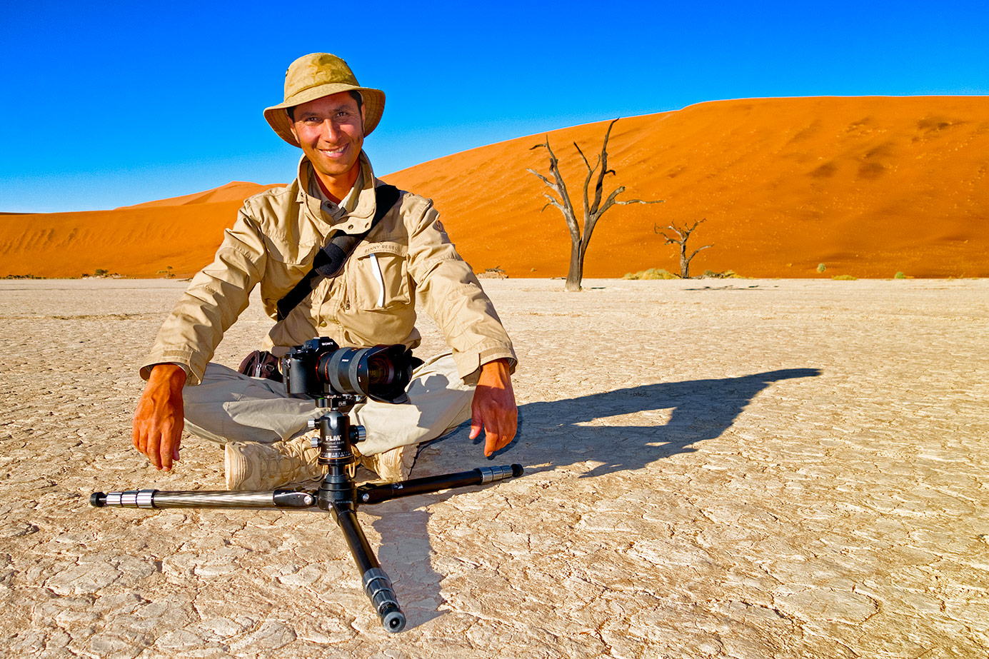 Benny Rebel sitzt im Dead Vlei auf einer Fotoreise durch Namibia. Fotosafari Namibia.
