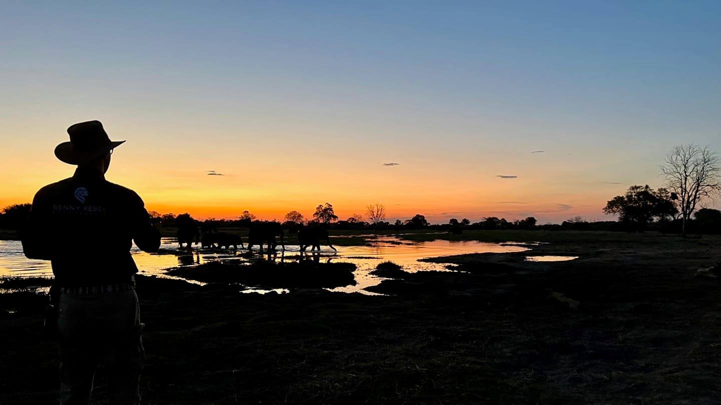 Auf dem Bild links seht Ihr mich am Khwai River in Botswana. Im Fluss stehen Elefanten und in meiner Hand befindet sich ein Glas Amarula.