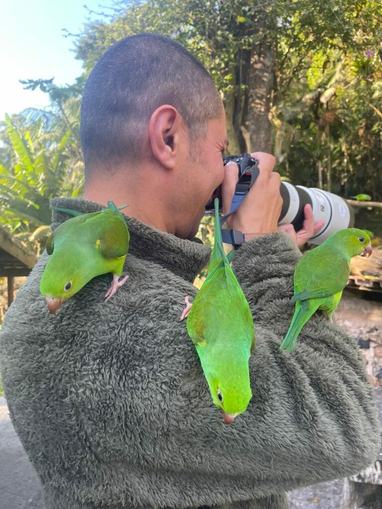 Benny Rebel mit Sittichen im Urwald Brasiliens.